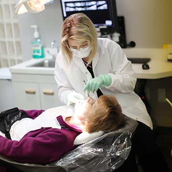 A dentist performing scaling and root planing