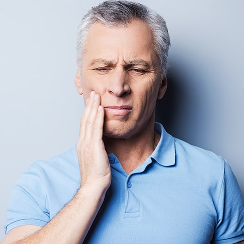 A man holding his tooth in pain
